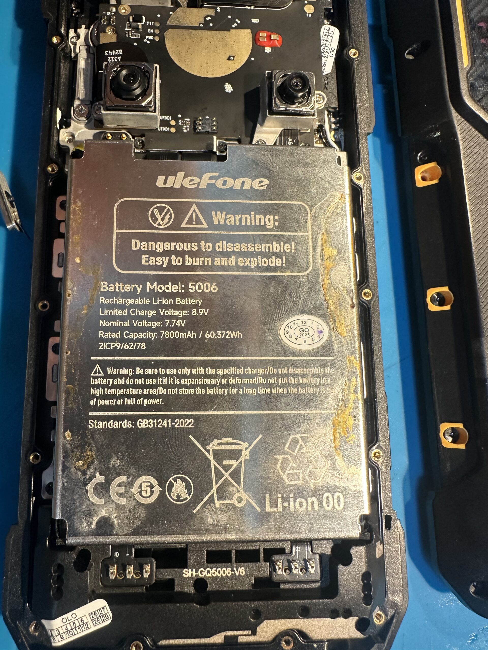 Ślady cieczy, osadu i korozji na baterii oraz wewnątrz Ulefone Armor 26 Ultra