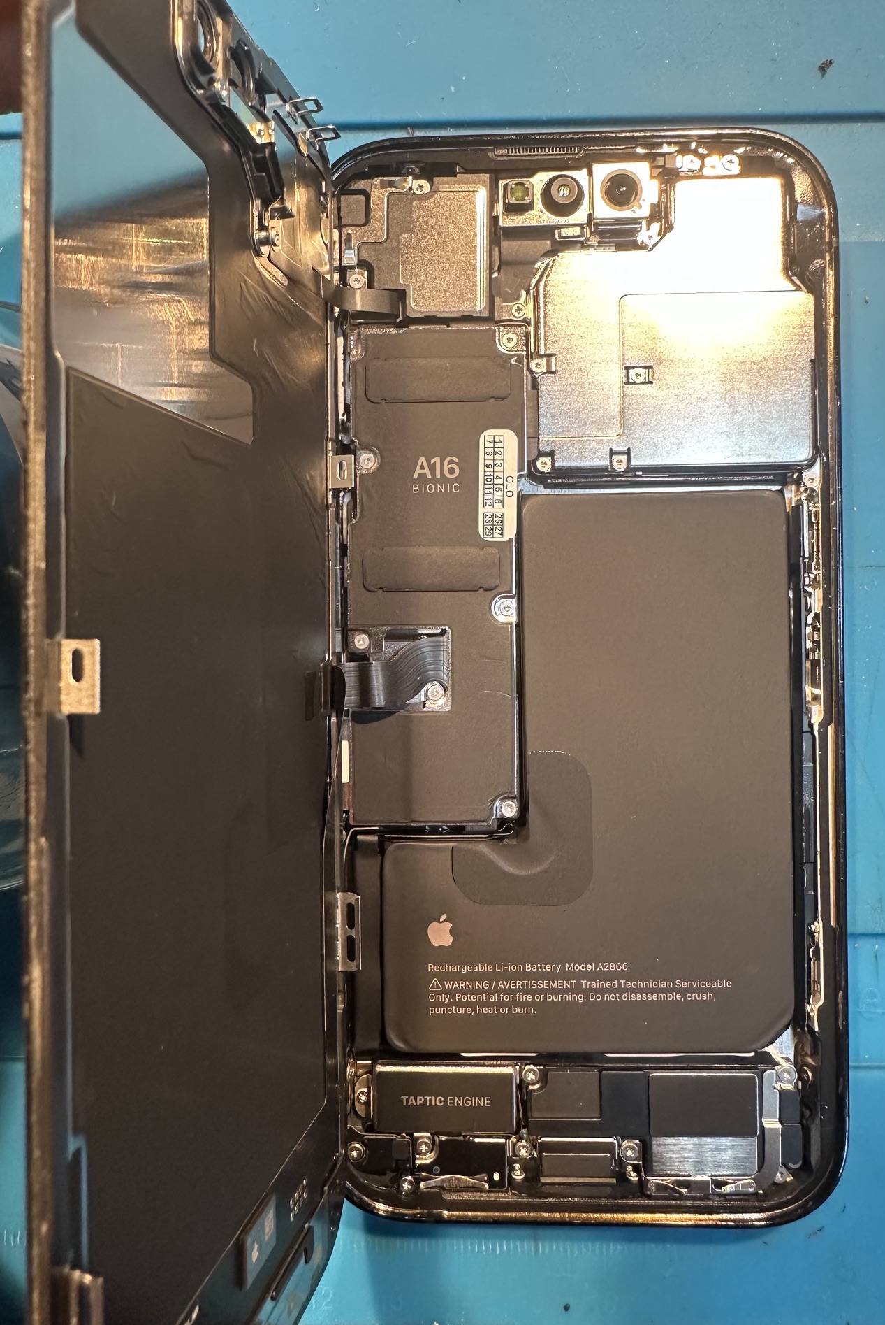 iPhone 14 Pro z nową baterią i osłonami złączy przed zamknięciem obudowy